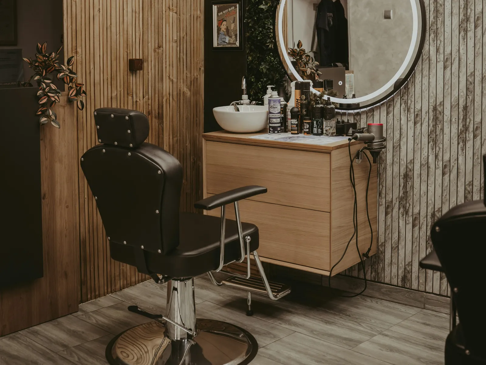 Fauteuil de coiffure devant un meuble en bois et un miroir rond